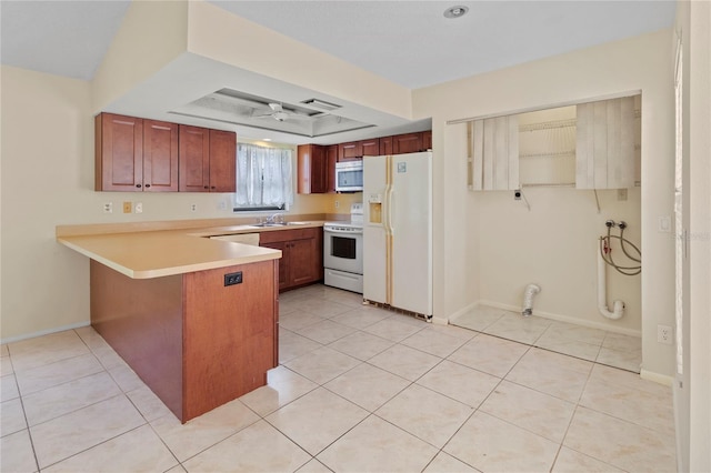 4805 Cypress Lake Ct, Sarasota, FL 34243 - kitchen with white appliances, a peninsula, light countertops, light tile patterned flooring, and a raised ceiling