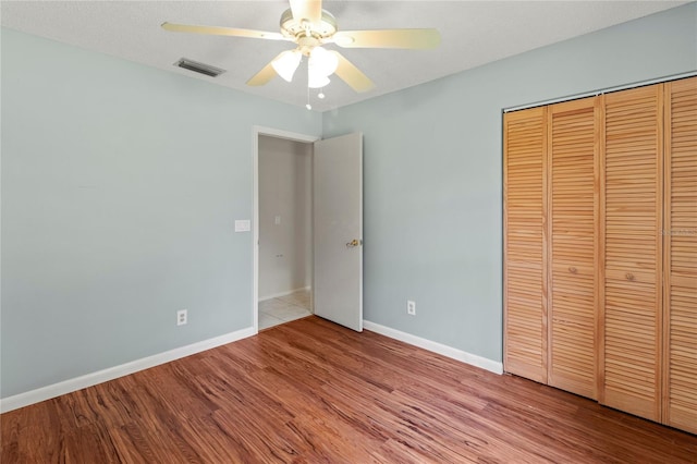 4805 Cypress Lake Ct, Sarasota, FL 34243 - unfurnished bedroom with wood finished floors, a closet, and a ceiling fan