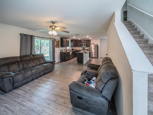 938 Mansfield Rd, Tavares, FL 32778 - living area featuring light wood-style flooring, a ceiling fan, and stairs