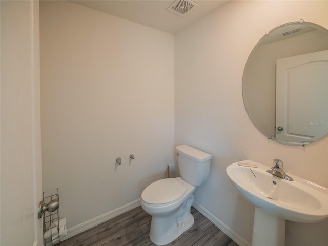 938 Mansfield Rd, Tavares, FL 32778 - half bathroom with toilet and wood finished floors