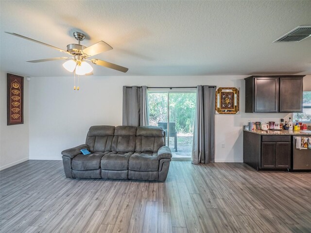 938 Mansfield Rd, Tavares, FL 32778 - living area featuring light wood-style floors, a ceiling fan, and a textured ceiling