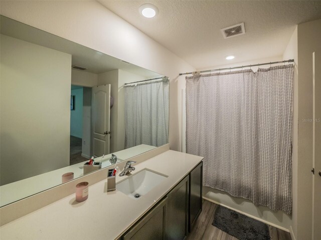 938 Mansfield Rd, Tavares, FL 32778 - full bath featuring vanity, wood finished floors, shower / tub combo, and a textured ceiling