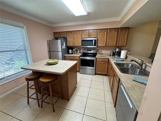 3810 75th St W Unit 137, Bradenton, FL 34209 - kitchen with appliances with stainless steel finishes, light countertops, a kitchen bar, brown cabinets, and light tile patterned floors