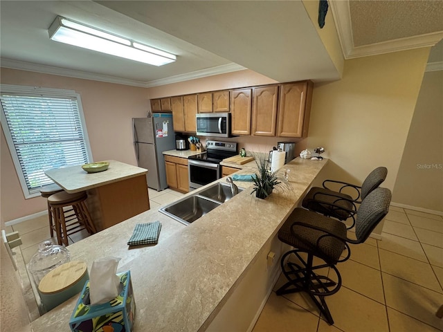 3810 75th St W Unit 137, Bradenton, FL 34209 - kitchen featuring appliances with stainless steel finishes, a kitchen breakfast bar, light tile patterned floors, light countertops, and crown molding