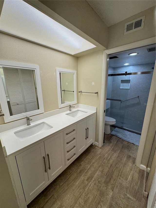 3810 75th St W Unit 137, Bradenton, FL 34209 - bathroom with double vanity, wood finished floors, and a tile shower