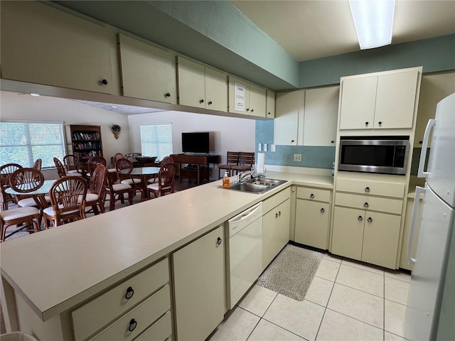 3810 75th St W Unit 137, Bradenton, FL 34209 - kitchen with white appliances, a peninsula, light countertops, light tile patterned floors, and healthy amount of natural light