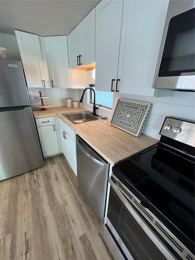 1871 Palm Springs St, Sarasota, FL 34234 - kitchen featuring appliances with stainless steel finishes, light wood-style floors, and white cabinets