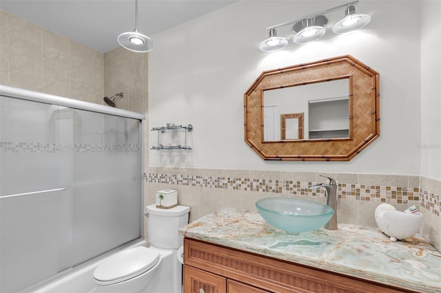 830 Egret Ln, Key Largo, FL 33037 - bathroom featuring tile walls, vanity, shower / bath combination with glass door, and wainscoting