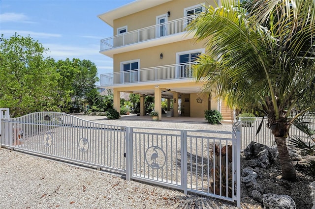 830 Egret Ln, Key Largo, FL 33037 - rear view of house featuring a gate, a balcony, and a fenced front yard