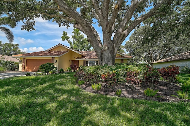 1674 Cottonwood Trl, Sarasota, FL 34232 - view of front of house featuring a garage, a front yard, stucco siding, and driveway