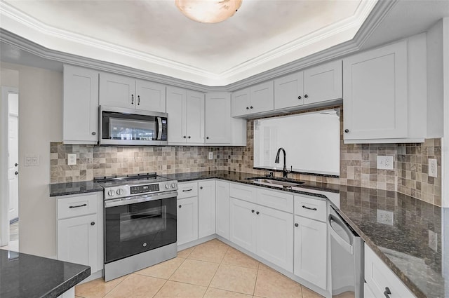 1674 Cottonwood Trl, Sarasota, FL 34232 - kitchen featuring appliances with stainless steel finishes, tasteful backsplash, light tile patterned flooring, a tray ceiling, and crown molding