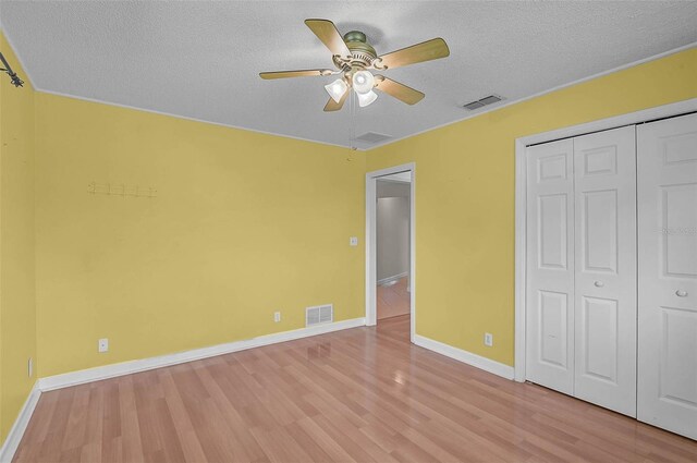 1674 Cottonwood Trl, Sarasota, FL 34232 - unfurnished bedroom with light wood-type flooring, a textured ceiling, a closet, and ceiling fan