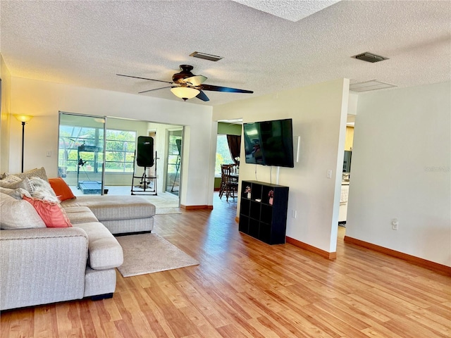 6806 18th Ave W, Bradenton, FL 34209 - living area featuring light wood finished floors, a textured ceiling, and a ceiling fan