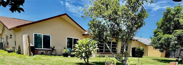 6806 18th Ave W, Bradenton, FL 34209 - rear view of property with stucco siding, a lawn, and a shingled roof