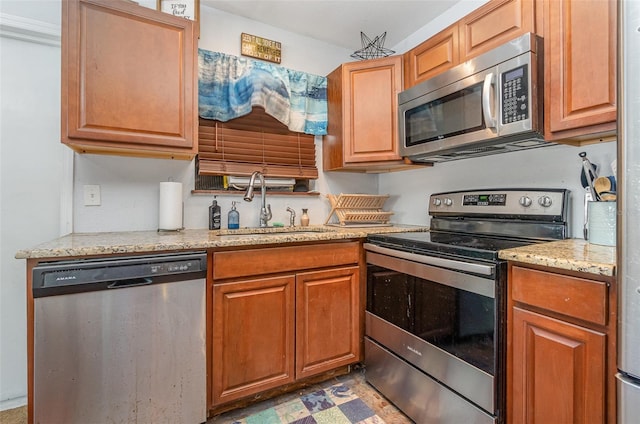 4481 Lagg Ave, Fort Myers, FL 33901 - kitchen featuring appliances with stainless steel finishes, light stone counters, light floors, and brown cabinetry
