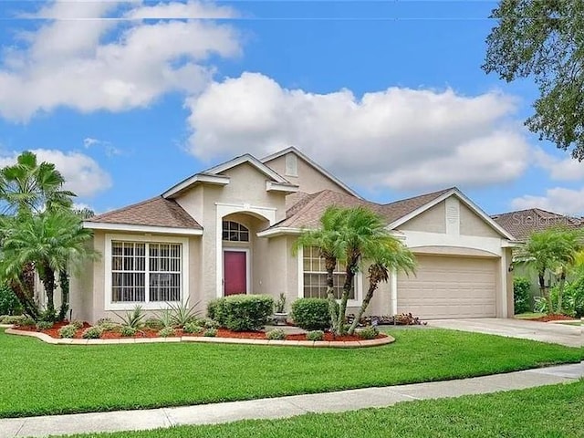 9406 Sarazen Pl, Palmetto, FL 34221 - view of front of property featuring a garage, stucco siding, concrete driveway, and a front lawn