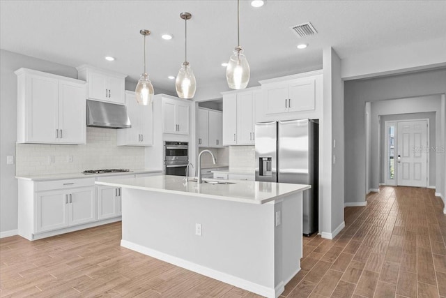 9292 Tequila Sunrise Dr, Sarasota, FL 34241 - kitchen with under cabinet range hood, appliances with stainless steel finishes, light countertops, decorative backsplash, and recessed lighting