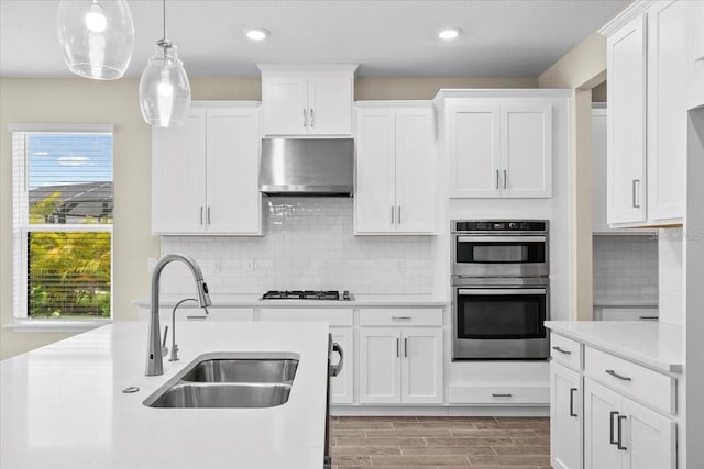 9292 Tequila Sunrise Dr, Sarasota, FL 34241 - kitchen featuring range hood, appliances with stainless steel finishes, light countertops, white cabinets, and recessed lighting