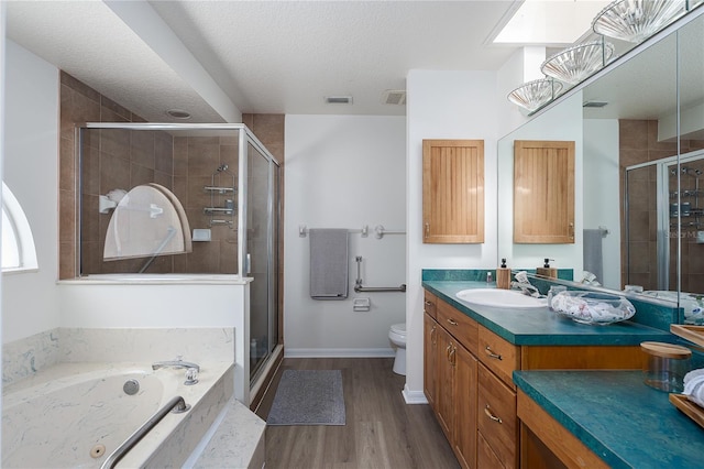 6114 68th Dr E, Palmetto, FL 34221 - bathroom with vanity, a shower stall, a bath, wood finished floors, and a textured ceiling