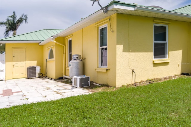 6114 68th Dr E, Palmetto, FL 34221 - view of home's exterior featuring stucco siding, a standing seam roof, a metal roof, and a yard