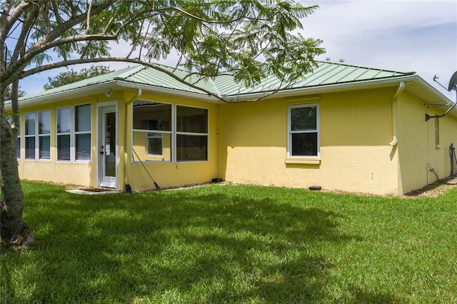 6114 68th Dr E, Palmetto, FL 34221 - back of house featuring stucco siding, a yard, and a standing seam roof