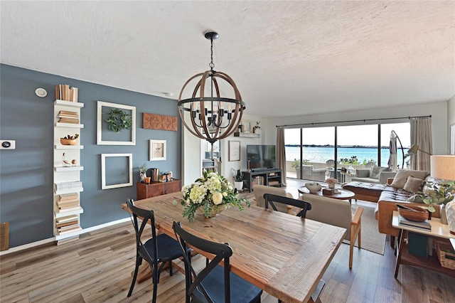 1510 1st Ave W Unit 102, Bradenton, FL 34205 - dining area with a chandelier, a textured ceiling, and wood finished floors