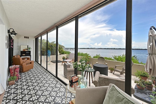1510 1st Ave W Unit 102, Bradenton, FL 34205 - sunroom featuring a water view, floor to ceiling windows, and a textured ceiling