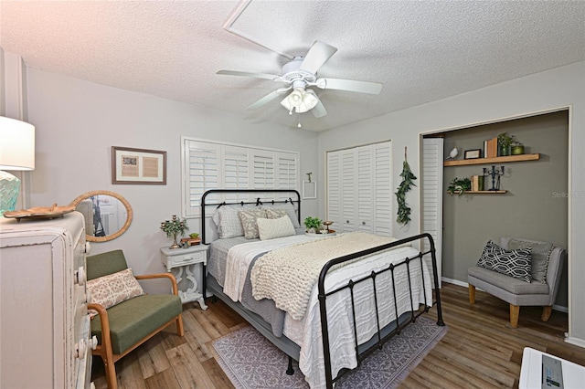 1510 1st Ave W Unit 102, Bradenton, FL 34205 - bedroom featuring light wood-style flooring, two closets, a textured ceiling, and a ceiling fan