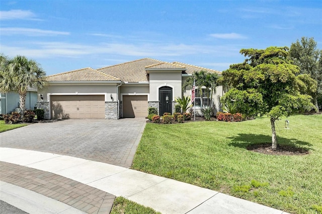3379 Chestertown Loop, Bradenton, FL 34211 - mediterranean / spanish-style home with an attached garage, stucco siding, stone siding, and a front yard