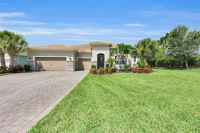 3379 Chestertown Loop, Bradenton, FL 34211 - mediterranean / spanish house with a garage, stucco siding, a front yard, decorative driveway, and stone siding
