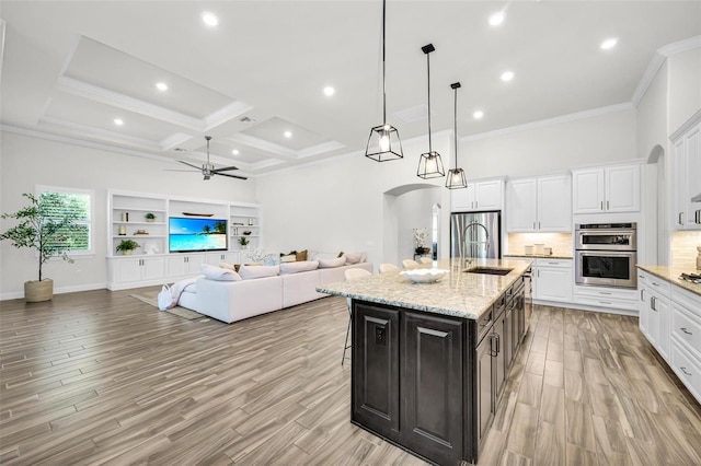 3379 Chestertown Loop, Bradenton, FL 34211 - kitchen with appliances with stainless steel finishes, arched walkways, a ceiling fan, white cabinetry, and open floor plan