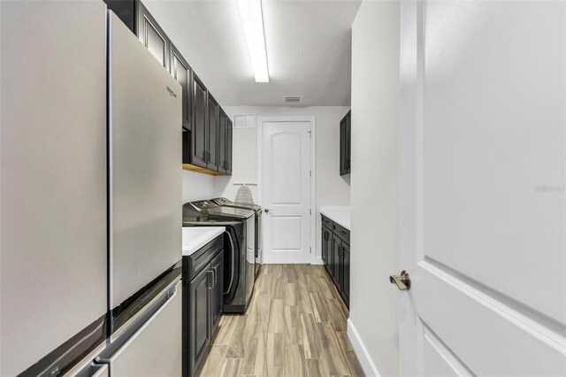 3379 Chestertown Loop, Bradenton, FL 34211 - washroom with cabinet space, washing machine and clothes dryer, and light wood-style floors