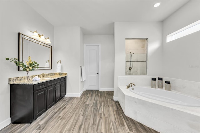3379 Chestertown Loop, Bradenton, FL 34211 - bathroom with vanity, a garden tub, wood finished floors, a tile shower, and recessed lighting
