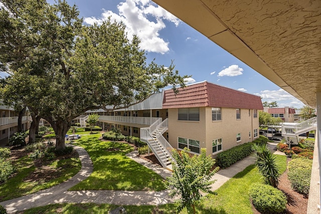 10037 62nd Ter N Unit 23, Saint Petersburg, FL 33708 - back of property with stairway, mansard roof, and a lawn