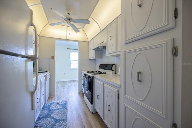 10037 62nd Ter N Unit 23, Saint Petersburg, FL 33708 - kitchen with white appliances, under cabinet range hood, a ceiling fan, light wood-type flooring, and light countertops