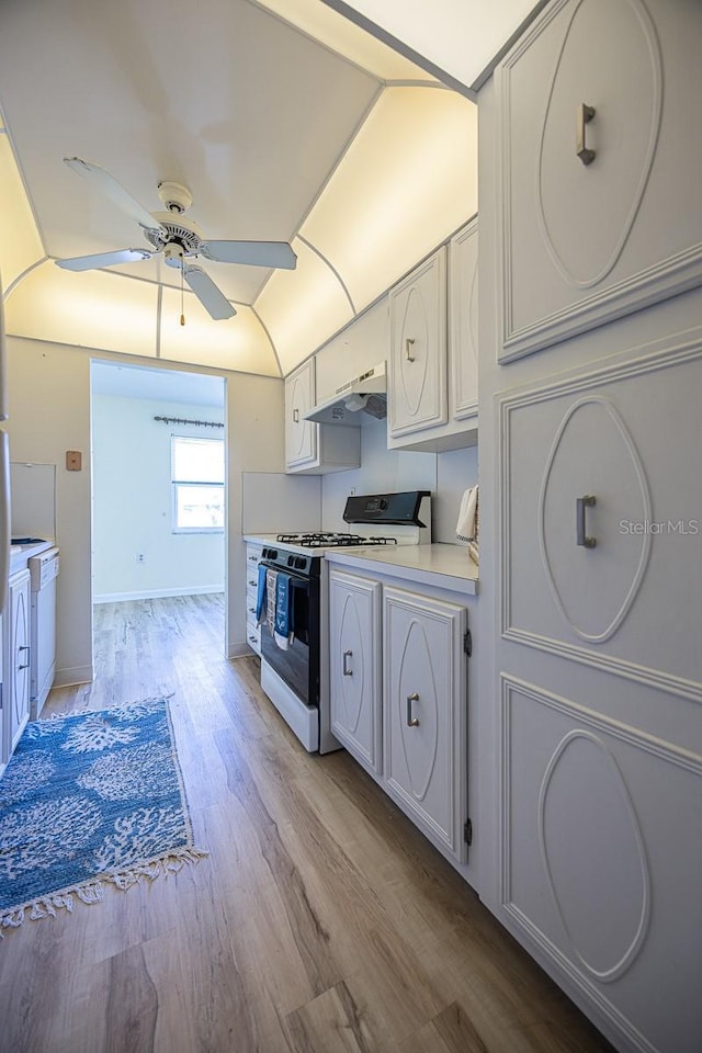 10037 62nd Ter N Unit 23, Saint Petersburg, FL 33708 - kitchen with white range with gas stovetop, ceiling fan, light wood-style flooring, under cabinet range hood, and light countertops