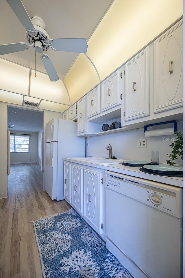 10037 62nd Ter N Unit 23, Saint Petersburg, FL 33708 - kitchen featuring white appliances, ceiling fan, light wood-style flooring, white cabinetry, and light countertops