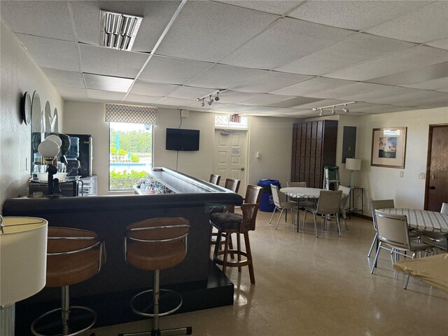 10037 62nd Ter N Unit 23, Saint Petersburg, FL 33708 - bar featuring a paneled ceiling, rail lighting, and concrete flooring