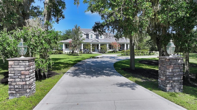 6050 Saddle Oak Trl, Sarasota, FL 34241 - view of front of house featuring a front yard, covered porch, and curved driveway