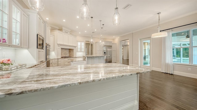 6050 Saddle Oak Trl, Sarasota, FL 34241 - kitchen featuring built in appliances, decorative backsplash, a peninsula, dark wood-type flooring, and white cabinetry