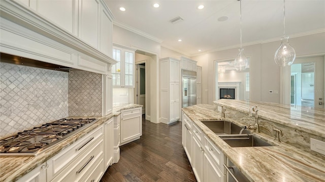6050 Saddle Oak Trl, Sarasota, FL 34241 - kitchen featuring stainless steel appliances, a warm lit fireplace, decorative backsplash, dark wood finished floors, and hanging light fixtures