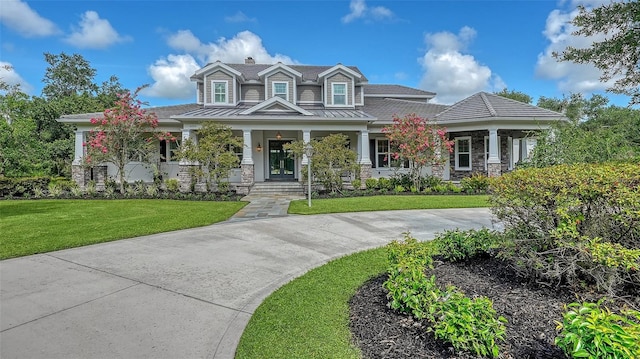 6050 Saddle Oak Trl, Sarasota, FL 34241 - view of front facade featuring a standing seam roof, covered porch, a front yard, stone siding, and a metal roof
