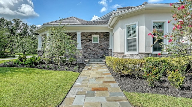 6050 Saddle Oak Trl, Sarasota, FL 34241 - doorway to property with a yard, stone siding, and stucco siding
