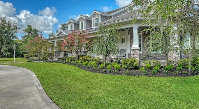 6050 Saddle Oak Trl, Sarasota, FL 34241 - view of front facade with a front yard, stone siding, and a porch