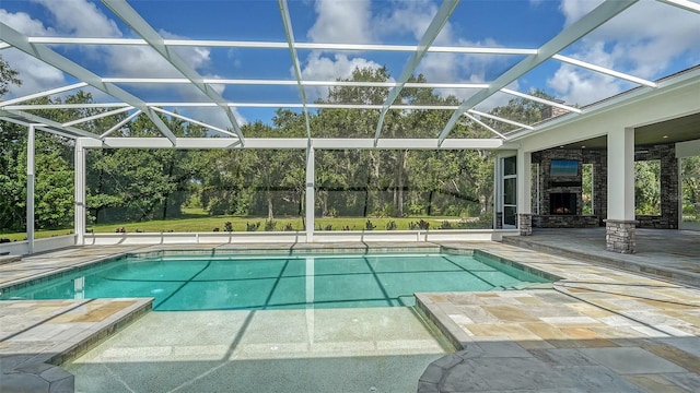 6050 Saddle Oak Trl, Sarasota, FL 34241 - outdoor pool featuring a patio area, an outdoor stone fireplace, and glass enclosure