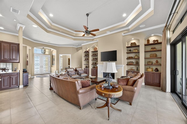 5104 Benito Ct, Bradenton, FL 34211 - living area with ornamental molding, built in shelves, a raised ceiling, a ceiling fan, and arched walkways