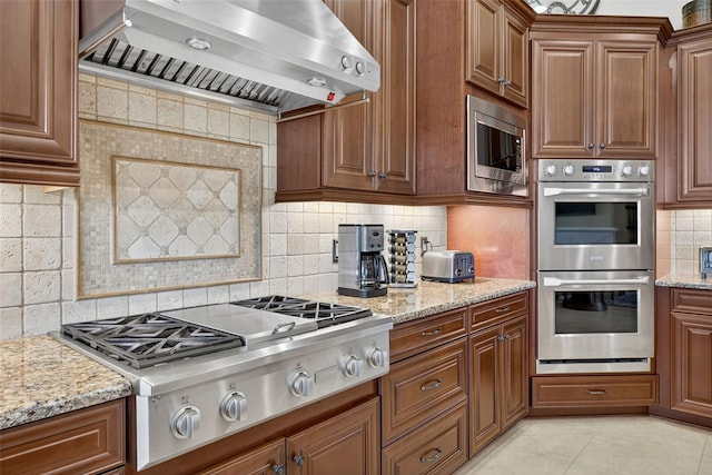 5104 Benito Ct, Bradenton, FL 34211 - kitchen featuring stainless steel appliances, wall chimney range hood, backsplash, and light stone counters