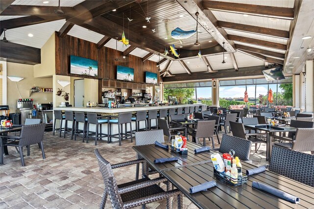 5104 Benito Ct, Bradenton, FL 34211 - dining area with brick floors, high vaulted ceiling, a wooden ceiling with exposed beams, and wooden walls