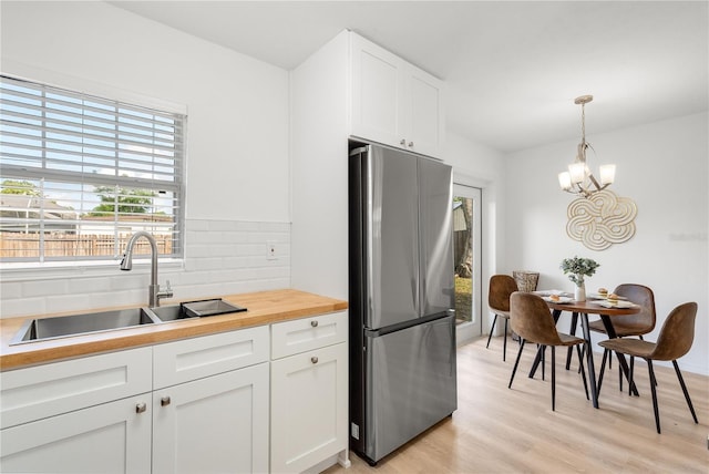2802 21st St W, Bradenton, FL 34205 - kitchen with freestanding refrigerator, backsplash, healthy amount of natural light, and light wood-style floors