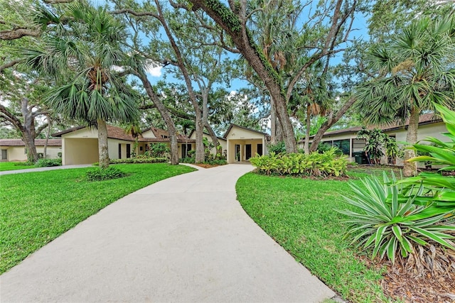 2237 Circlewood Dr Unit 18, Sarasota, FL 34231 - view of front of home featuring concrete driveway, a front lawn, stucco siding, and a carport